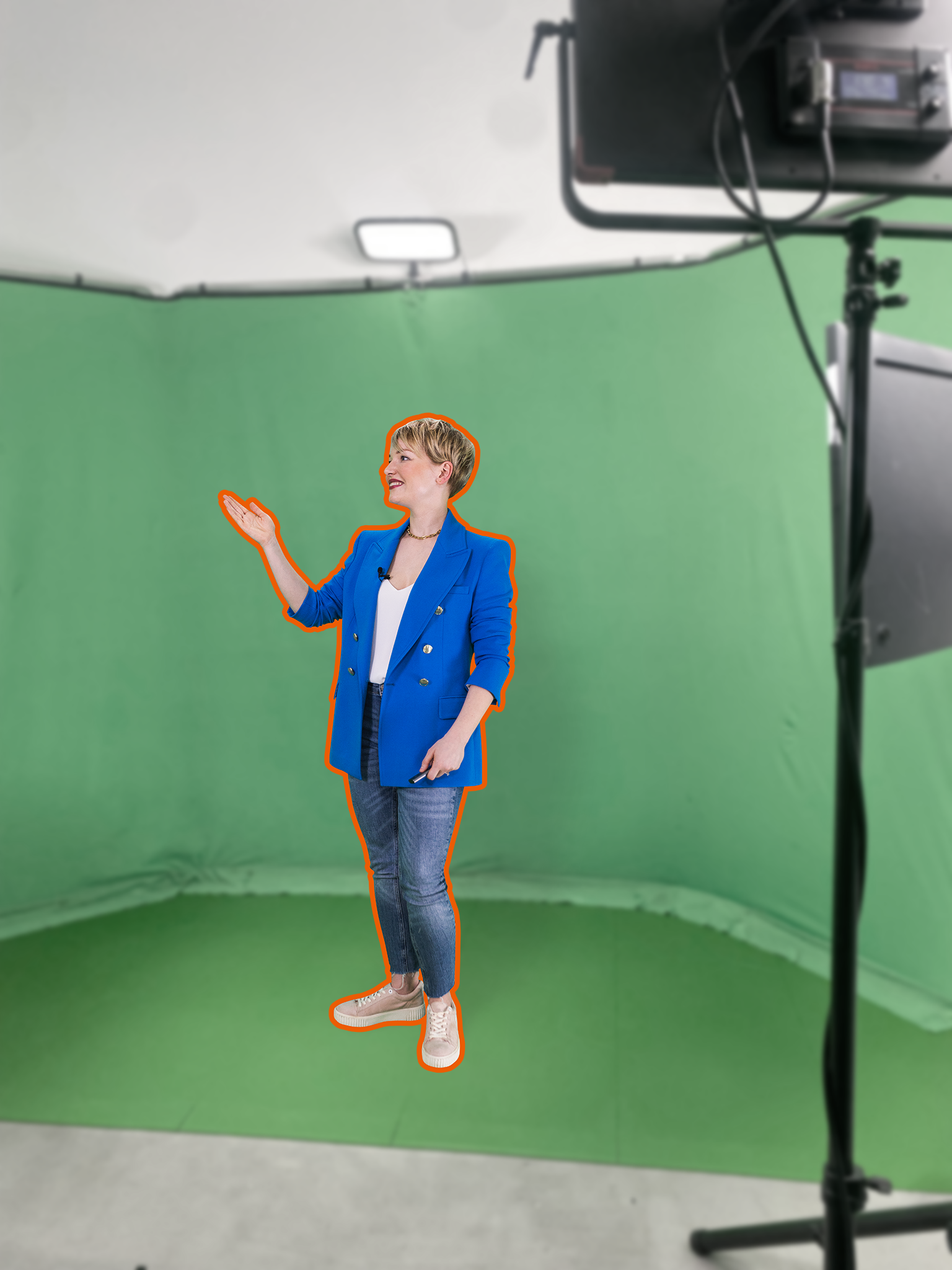 Frau steht vor einem greenscreen mit orange farbender Umrandung